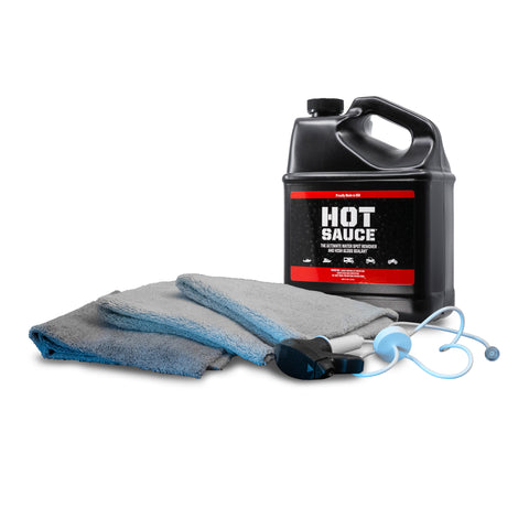 Premium Hot Sauce To-Go Kit featuring a large bottle of cleaning solution, microfiber towels, and detailing tools for vehicle care.