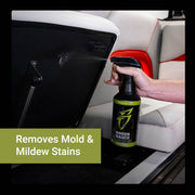 Green Sauce spray bottle in hand, targeting mold and mildew stains on a boat seat for effective cleaning.