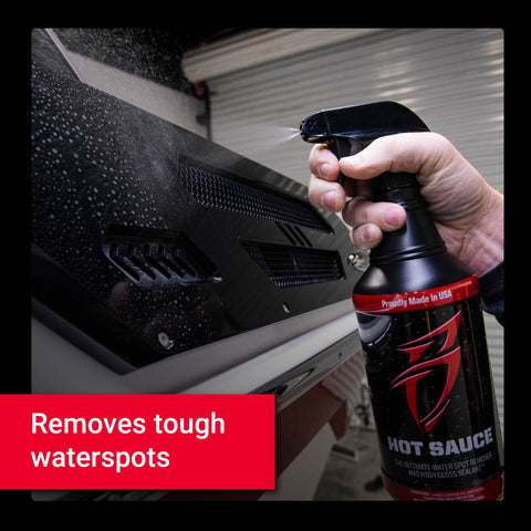 A person sprays Hot Sauce on a vehicle surface, effectively removing tough water spots for a glossy finish.