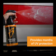 Hand holding a spray bottle of Quickie Sauce, applying a protective coating on a vehicle's surface for UV protection.