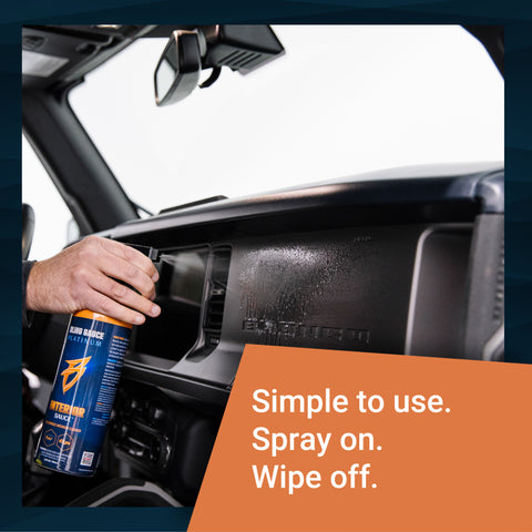 A person spraying Interior Sauce on a vehicle dashboard, demonstrating easy application for cleaning.
