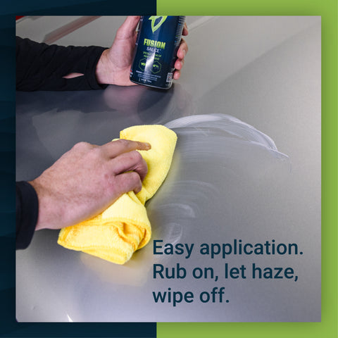 A person applying Fusion Sauce to a car's surface with a yellow microfiber cloth, demonstrating easy application.