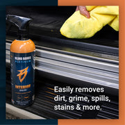 Premium interior cleaner bottle with a person using a yellow cloth to wipe a vehicle surface, showcasing easy dirt removal.