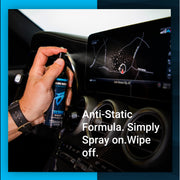 Hand holding a bottle of Techno Sauce, an anti-static formula, ready to spray on a car's touchscreen display.