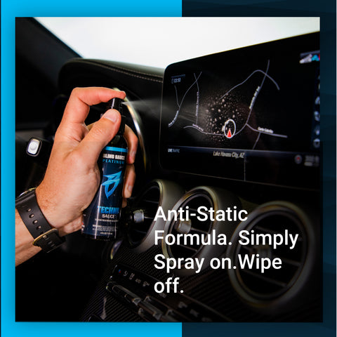 Hand holding a bottle of Techno Sauce, an anti-static formula, ready to spray on a car's touchscreen display.